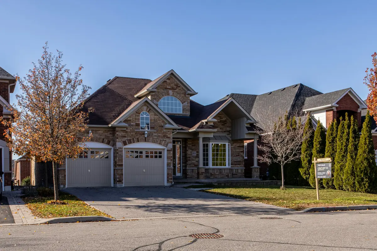Stone home with two white raised-panel garage doors